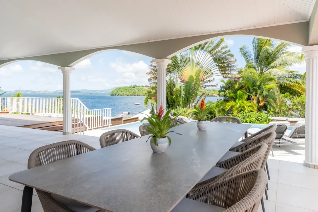 Terrasse Villa Table en extérieur avec vue sur la mer et des palmiers dans un cadre tropical.