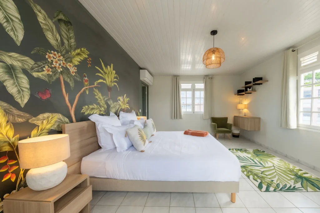 Chambre Tropicale Villa Bel Embrun Chambre lumineuse avec mur végétal, lit double et décor moderne.