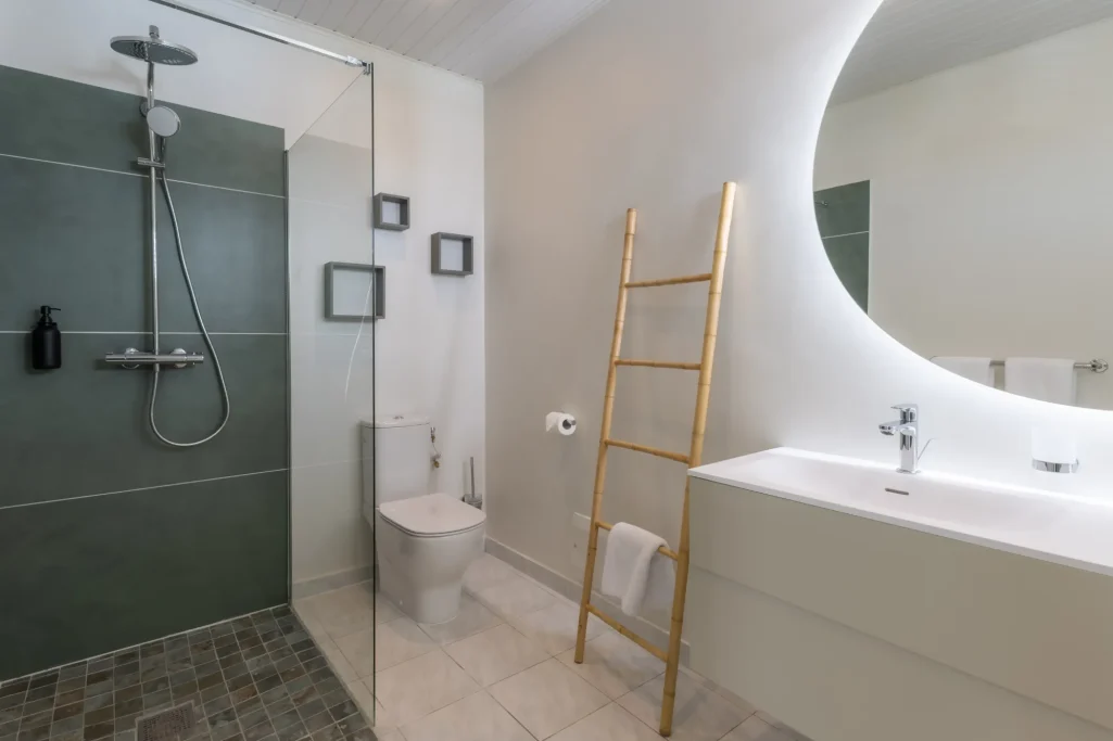 Salle de douche Salle de bains moderne avec douche, toilettes et lavabo sur un mur clair.