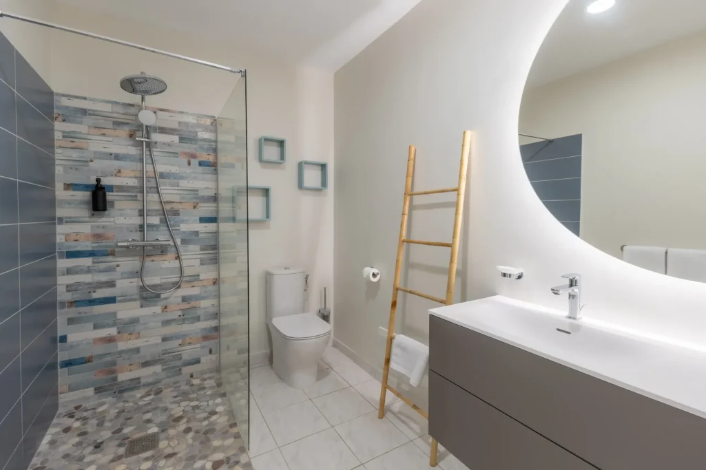 Salle de douche Villa Bel Embrun Salle de bains moderne avec douche, lavabo et décoration minimaliste.